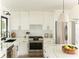 Bright kitchen features sleek white cabinets, stainless steel appliances, and marble counters at 3920 Basswood Dr, Sarasota, FL 34232