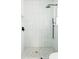 Modern shower with sleek white tiles, black fixtures, and pebble-style floor at 3920 Basswood Dr, Sarasota, FL 34232