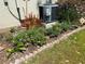 A brick-bordered garden bed enhances the curb appeal and surrounds the air conditioner and an antique cart at 10533 Hazel St, Largo, FL 33778