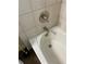 Close-up of a tiled bathtub with polished chrome fixtures and a shower head at 10533 Hazel St, Largo, FL 33778
