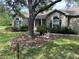 Charming home with a lush lawn, mature trees, and a beautifully landscaped front exterior at 10533 Hazel St, Largo, FL 33778