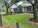 Beautiful home with a manicured lawn, mature trees, and a charming, well-kept exterior at 10533 Hazel St, Largo, FL 33778