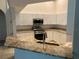 Well-lit kitchen showcasing granite countertops, white cabinets, and stainless steel appliances at 10533 Hazel St, Largo, FL 33778