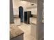 Open kitchen with white cabinets, granite countertops, stainless refrigerator, and tiled flooring at 10533 Hazel St, Largo, FL 33778