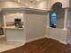 View of the living room and eat-in kitchen featuring decorative columns and granite counters at 10533 Hazel St, Largo, FL 33778