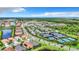 Picturesque aerial view of a community with tennis courts, a clubhouse, lakes, and tree-lined streets at 15503 Corona Del Mar Dr, Wimauma, FL 33598
