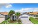 Attractive single-story home featuring a paved driveway, tropical landscaping, and an attached two-car garage at 15503 Corona Del Mar Dr, Wimauma, FL 33598