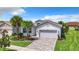 Attractive single-story home featuring a paved driveway, tropical landscaping, and an attached two-car garage at 15503 Corona Del Mar Dr, Wimauma, FL 33598