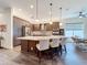 Bright kitchen with an island, pendant lighting, stainless appliances, and brown cabinetry at 15503 Corona Del Mar Dr, Wimauma, FL 33598