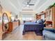 Spacious main bedroom featuring wood tile flooring, tray ceiling, large dressers and bright natural light at 15503 Corona Del Mar Dr, Wimauma, FL 33598