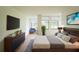 A comfortable bedroom with a mounted TV and bright, natural light with golf course views at 1967 Cormorant Ct # 516, Clearwater, FL 33762