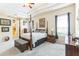 Primary bedroom featuring a four-poster bed, carpeted floors, and a tray ceiling at 20074 Heritage Point Dr, Tampa, FL 33647