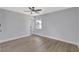 Clean bedroom featuring wood floors, fresh paint, modern ceiling fan, and window at 4928 Stolls Ave, Tampa, FL 33615