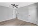 Spacious bedroom featuring a ceiling fan, light gray walls and light-colored laminate flooring at 4928 Stolls Ave, Tampa, FL 33615