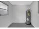 Utility room featuring an upright water heater and a window providing natural light at 4928 Stolls Ave, Tampa, FL 33615