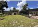 Big backyard with grass, trees and a screened in pool and nearby shed at 5627 Oakland Dr, Tampa, FL 33617