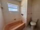 Bathroom features a window, pink tiled walls, and vintage fixtures at 5627 Oakland Dr, Tampa, FL 33617
