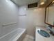 Bright bathroom featuring a white tiled shower/tub, and a vanity sink with a blue basin at 5627 Oakland Dr, Tampa, FL 33617