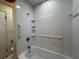 Bathroom featuring a tiled shower/tub, grab bars, and storage shelves at 5627 Oakland Dr, Tampa, FL 33617