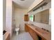 Bathroom featuring a double vanity with pink countertops, tiled flooring, and vintage fixtures at 5627 Oakland Dr, Tampa, FL 33617