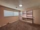 Bright bedroom with carpet, window with blinds, and a built-in shelving unit with cabinets at 5627 Oakland Dr, Tampa, FL 33617