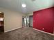 Bedroom features a red accent wall, carpet flooring, closet with shelving, and natural light at 5627 Oakland Dr, Tampa, FL 33617