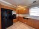 A well-lit kitchen showcasing wood cabinets, tiled floors, and modern black appliances at 5627 Oakland Dr, Tampa, FL 33617
