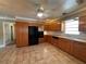 Bright kitchen featuring tile floors, wood cabinets, black appliances, and a ceiling fan at 5627 Oakland Dr, Tampa, FL 33617