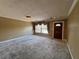 Bright living room features neutral carpet, large window, and dark wood front door at 5627 Oakland Dr, Tampa, FL 33617