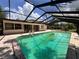 Relaxing screened in pool with adjacent white exterior of home and sliding glass doors at 5627 Oakland Dr, Tampa, FL 33617