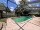 Enclosed pool with screen for outdoor enjoyment and privacy with a light pink concrete patio at 5627 Oakland Dr, Tampa, FL 33617