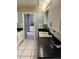 Well-lit kitchen with white cabinets, black countertops, and a view to an adjacent room at 4650 Orlando Cir, Bradenton, FL 34207