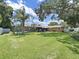 Expansive backyard featuring lush lawn, screened-in pool, mature trees, and privacy fence at 2531 Lake Ellen Dr, Tampa, FL 33618