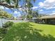 Spacious backyard with well-maintained lawn, white fence, and mature trees offering ample shade at 2531 Lake Ellen Dr, Tampa, FL 33618