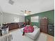 Bedroom with a ceiling fan, two windows, tiled floor, and a mixture of old and new furniture at 2531 Lake Ellen Dr, Tampa, FL 33618