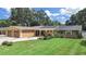 Charming single-story home featuring a well-manicured lawn, solar panels, and an attached two-car garage at 2531 Lake Ellen Dr, Tampa, FL 33618