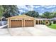 Residential exterior showcasing a two-car garage, solar panels, and mature trees at 2531 Lake Ellen Dr, Tampa, FL 33618