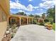 Inviting home exterior featuring a quaint front porch, lush landscaping, and a spacious concrete driveway at 2531 Lake Ellen Dr, Tampa, FL 33618