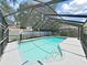 Sparkling screened-in pool with a diving area, situated in a backyard with fencing and some surrounding trees at 2531 Lake Ellen Dr, Tampa, FL 33618