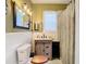 Well-lit bathroom featuring a modern vanity, commode, and decorative mirror at 2904 Sanchez St, Tampa, FL 33605