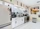 Galley-style kitchen featuring stainless appliances, white cabinets, and marble tile flooring at 2904 Sanchez St, Tampa, FL 33605