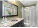 Stylish bathroom with decorative flamingo wall art, a granite vanity, and a glass-enclosed shower at 15007 Laurel Cove Cir, Odessa, FL 33556
