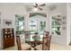 Bright breakfast nook features a glass table, wicker chairs, and views of the pool and lake at 15007 Laurel Cove Cir, Odessa, FL 33556