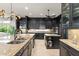 Modern kitchen with dark cabinets, stone countertops, stainless steel appliances and pendant lighting at 15007 Laurel Cove Cir, Odessa, FL 33556