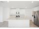 Modern kitchen features granite countertops, stainless steel appliances, and bright white cabinets at 3544 Moscato Dr, Brooksville, FL 34602