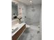 Modern bathroom with vessel sink, wood vanity, marble tile shower, and flower accents at 1300 Pleasant S Way, St Petersburg, FL 33705