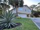 Front exterior of home featuring a large agave plant and green grass at 1300 Pleasant S Way, St Petersburg, FL 33705