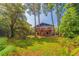 Charming exterior of home with lush lawn, mature trees, and multi-tiered deck at 1300 Pleasant S Way, St Petersburg, FL 33705