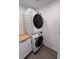 Stacked washer and dryer in the laundry area with wood countertop on adjacent cabinet at 1300 Pleasant S Way, St Petersburg, FL 33705