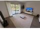 Cozy living room with rug, TV, modern decor, and sliding glass doors to outdoor patio at 1300 Pleasant S Way, St Petersburg, FL 33705